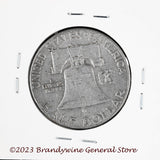 A 1956 Franklin Half Dollar in average circulated condition reverse side of coin