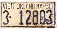 Vintage license plate from Oklahoma with text 'VISIT OKLAHOMA 58' and numbers '3-12803'.