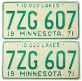 Pair of vintage 71 Minnesota license plates with green text on a beige background.