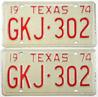 Two vintage Texas license plates from 1974 with red text on a beige background.
