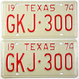 Pair of vintage Texas license plates from 1974 with red text on a beige background.