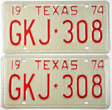 Pair of vintage Texas license plates from 1974 with red text on a beige background.