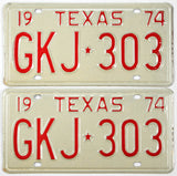 Pair of vintage Texas license plates from 1974 with red text on a beige background.
