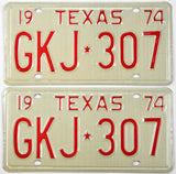 Pair of vintage Texas license plates from 1974 with red text on a beige background.
