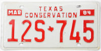 Texas Conservation license plate from March 1984 with red text on a white background