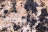 art print of brown rock with black veins and specks of gold