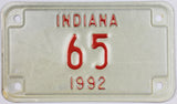 A NOS 1992 Indiana motorcycle license plate with a low DMV registration number. The 92 IN plate is in Excellent Minus condition.