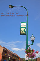 An archival premium Quality Art Print of Streetlight with a Gatlinburg Music Flag, showing the tall light towering above the city street for sale by Brandywine General Store