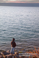 A premium quality art print of boy at the lake showing a boy in a brown coat staring wistfully into the waters of Lake Otesaga
