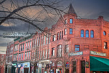 A premium quality art print of Cooperstown Gothic Buildings under a Stormy Sky with the wax museum on the corner