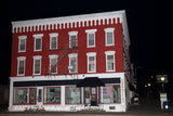 An art print of Cooperstown Red Brick Building with White Trim at Night