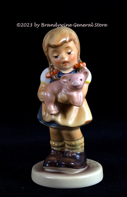 A Goebel Hummel figurine titled Pigtails with a girl in pigtails holding a small pig from trademark 7