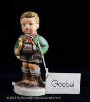 A Hummel figurine titled Trumpet Boy with the original Goebel hang tag and the label on the back of the base, with half the label needing attached again