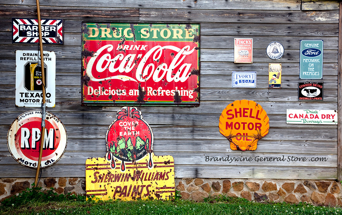 A premium art print of Shell Oil, Coke, Ivory Soap and more Ads nailed to a shed