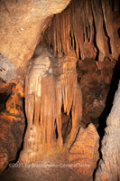 A fine art print of a small chasm in Luray Caverns with ribbons hanging from the ceiling resembling smoked sides of bacon