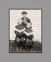 An art print of Three Children and a Kitten from an Antique Photograph with the boy holding a kitten, unusal for pets to be in the pictures from this era